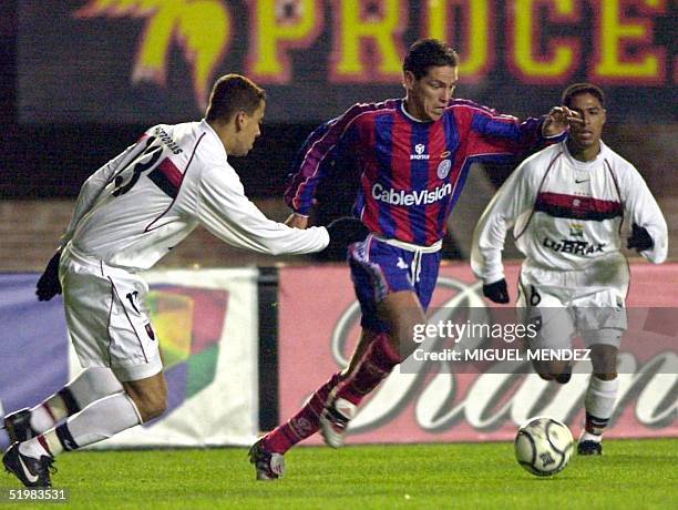 Walter Erviti , of San Lorenzo de Almagro, fights for the ball with Flamengo's Fernando and Franco , during their Copa Mercosur game in Buenos Aires,...