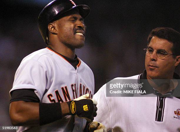 San Francisco Giants' Shawon Dunston is checked by a team trainer after getting hit by Arizona Diamondbacks' pitcher Randy Johnson during the eighth...
