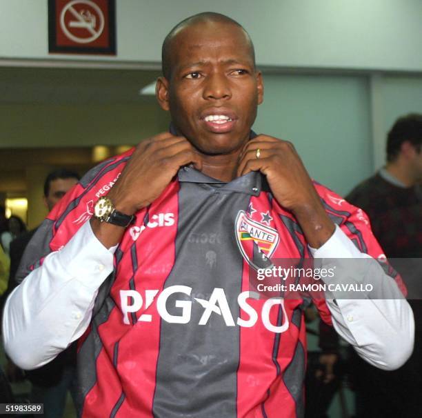 Colombian footballer Faustino Asprilla pulls on the jersey of his new team as he is greeted by fans upon his arrival at Mexico City airport 01 August...