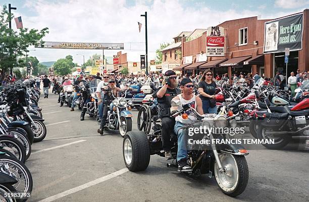 Bikers roll down main street during the 61st annual motorcycle rally held 06-12 August, 2001 in Sturgis, South Dakota. Thousands of bikers from...