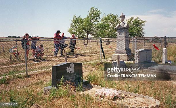 This August, 2001 photo shows tourists visiting the burial site of Lakota Native Americans killed in the 29 December 1890 massacre by US Army...
