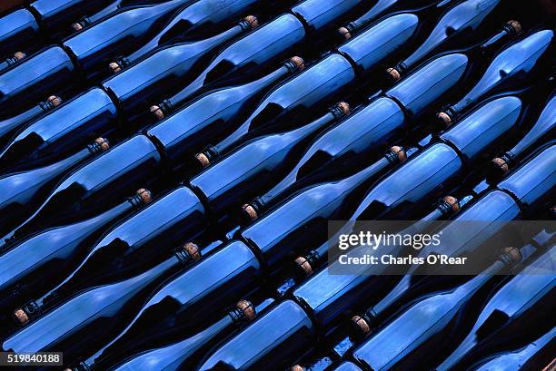 champagne bottles waiting for labels at argyle winery - wine bottle stock pictures, royalty-free photos & images