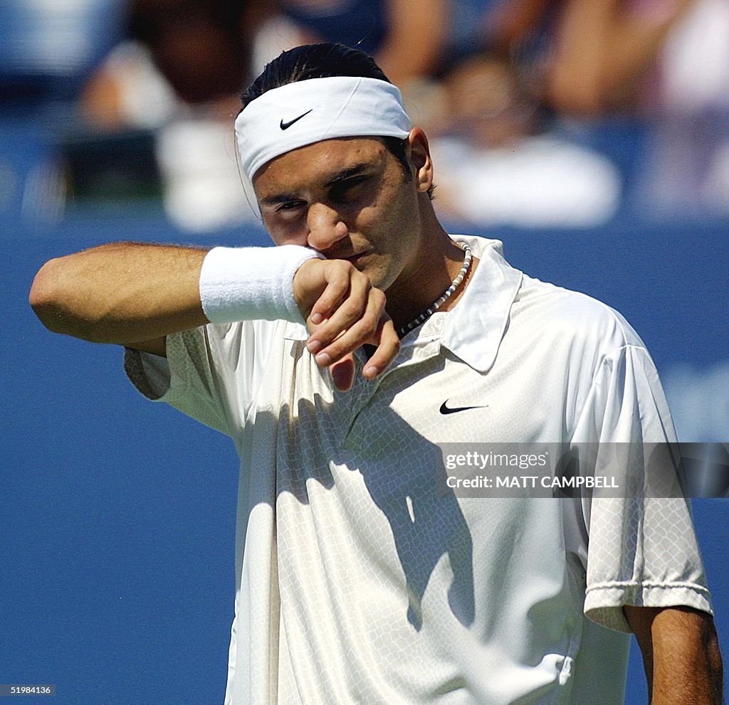 Roger Federer of Switzerland wipes his face during