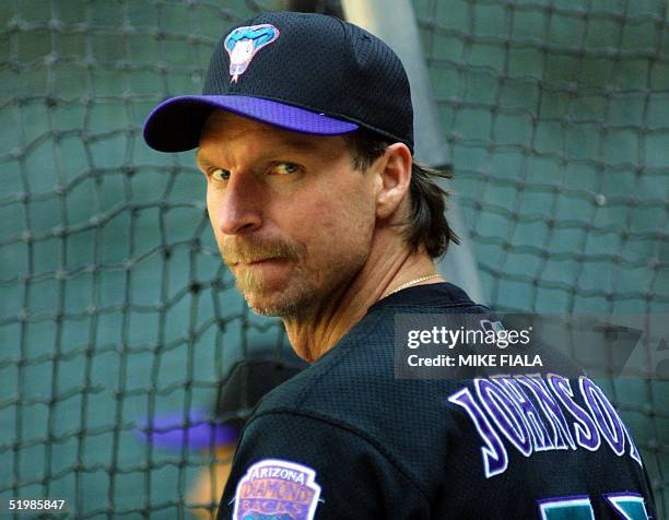Arizona Diamondbacks' pitcher Randy Johnson waits his turn in the batting cage during an afternoon workout at Bank One Ballpark 24 October 2001 in...