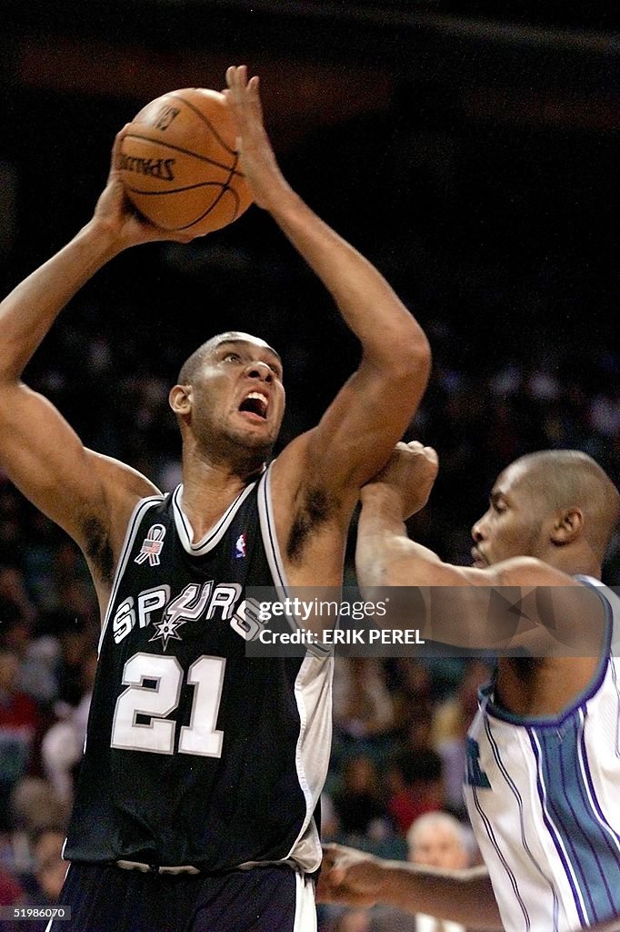 San Antonio Spurs Tim Duncan (L) puts up a shot as