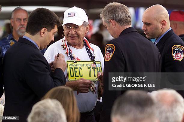 Everett, Washington, resident Glenn Freundenberger , wearing his car's vanity plate, is greeted a number of unidentified New York City Firemen who...