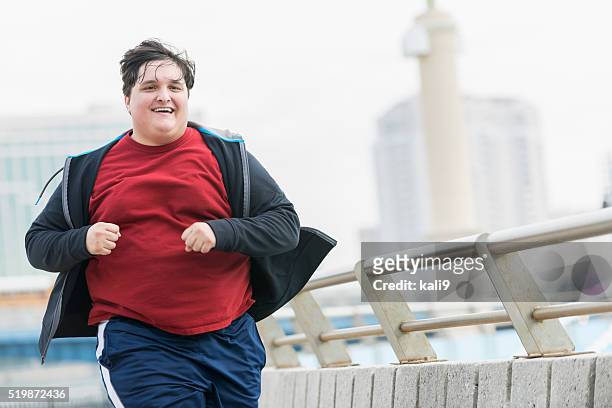 overweight young man running to lose weight - chubby men stock pictures, royalty-free photos & images