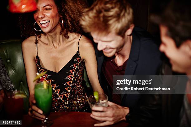 friends having drinks and hanging out at a bar. - people laughing at a party stock pictures, royalty-free photos & images