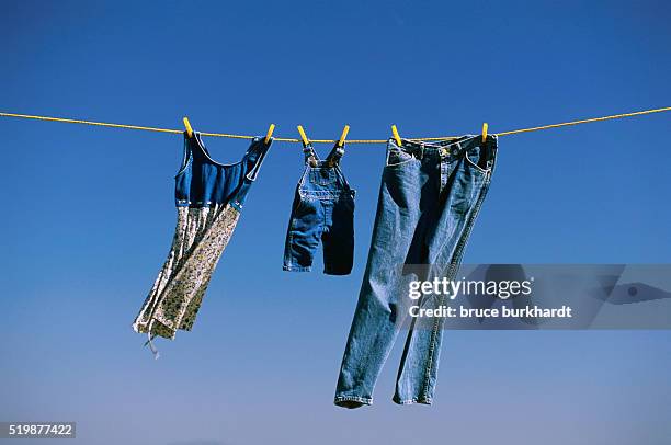 blue family clothes on clothesline - vintage jeans stock pictures, royalty-free photos & images