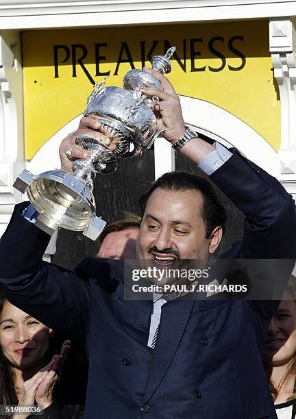 War Emblem's owner Saudi Prince Ahmed bin Salman holds up the Woodlawn Vase after the 127th Preakness Stakes 18 May 2002 at Pimlico race track in...