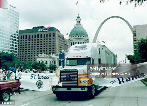 Moving van, part of a convoy of trucks carrying the equipment of the newly transplanted St. Louis Rams football team, breaks through a welcoming...