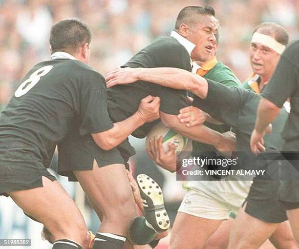 New Zealand winger Jonah Lomu strains to get through the Springbok defense during the rugby World Cup final at Ellis Park in Johannesburg 24 June. At...