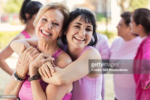 nieta abrazos abuela en diversión de caridad - concienciación sobre el cáncer de mama fotografías e imágenes de stock