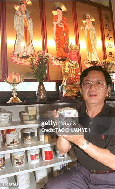 Koo Tsun-yi, owner of a funeral parlor for pets, shows 13 June a small urn containing the cremated ashes of a dog, sent to the Taipei parlor for...