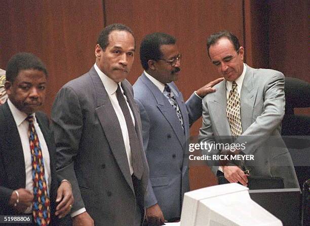 Murder defendant O.J. Simpson and his attorneys Carl Douglas and Johnnie Cochran, Jr and Robert Shapiro stand 12 June as the jury enters the...