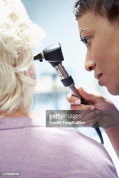 患者の耳を調べる看護師 - 耳の検査 ストックフォトと画像