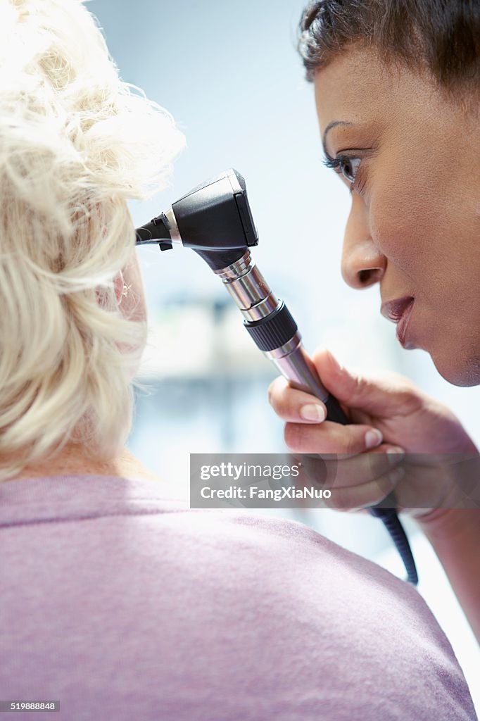 Nurse examining a patient's ear