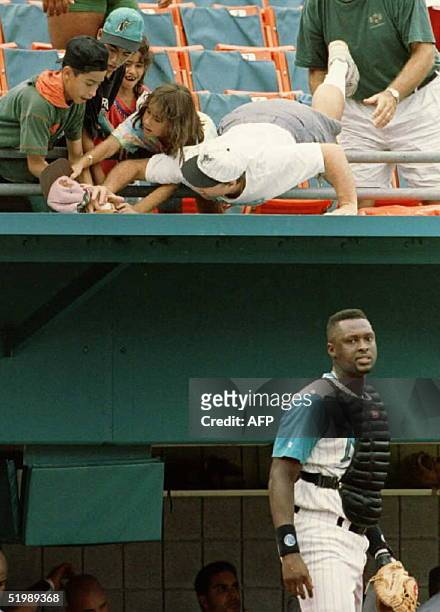 Florida Marlin's catcher Charles Johnson walks back to home plate after giving chase to a pop foul ball by Tony Gwynn in the top of the seventh...