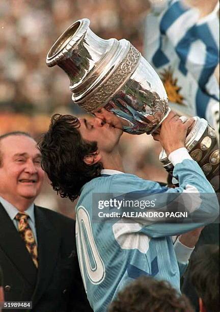 Nicolas Leoz,presidente de la Confederacion Sudamericana de Futbol observa al capitan de Uruguay Enzo Francescoli quien besa la Copa America el 23 de...