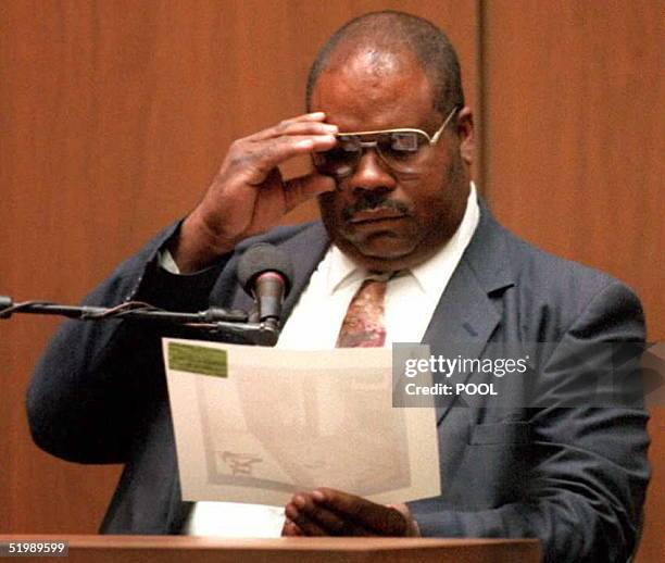 Los Angeles Police Department videographer Willie Ford examines a photo of O.J. Simpson's bedroom 20 July during the Simpson double- murder trial....