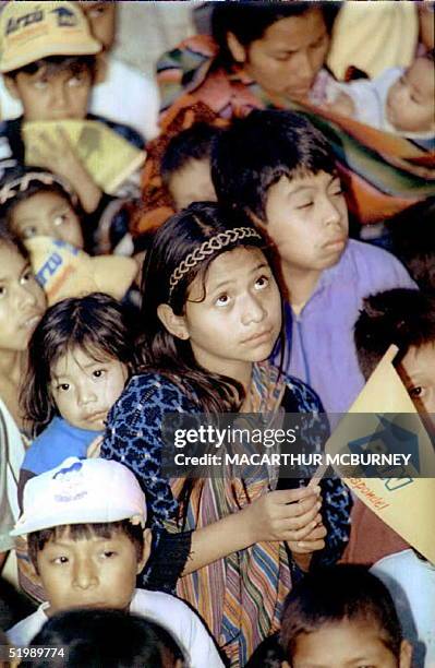 Young indigenous girl holding a flag from Guatemala's opposition conservative Party for National Advancement listens to a speech by PAN leader and...