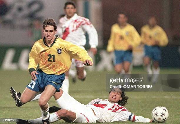 Savio de Brasil elude al peruano Jose Del Solar durente el primer tiempo del partido disputado el 10 de Julio en Rivera por el grupo "B" de la Copa...