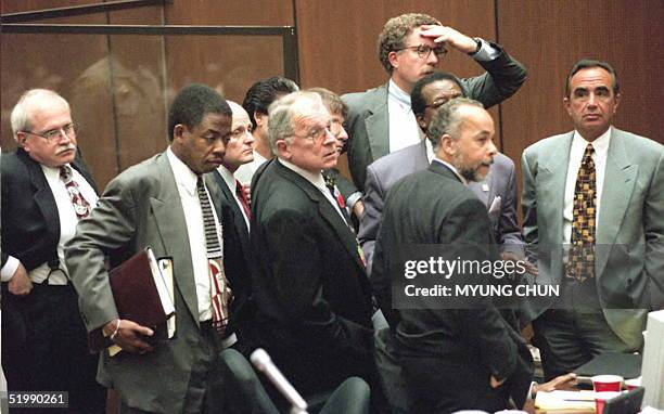 All the members of the O.J. Simpson defense team huddle around Simpson at the end of a controversial court day 29 August in Los Angeles. Tapes of...