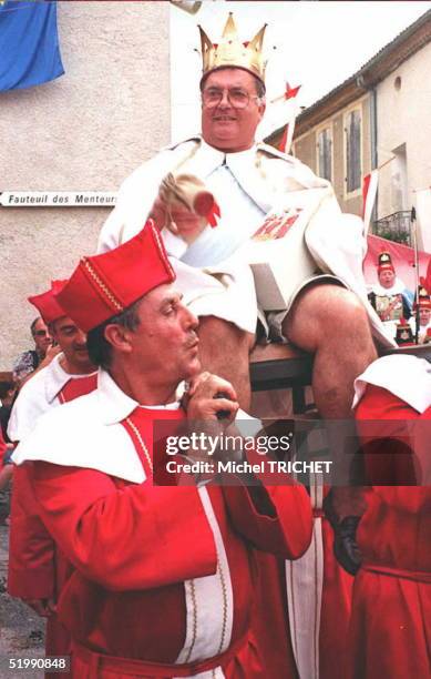 Michel is carried on his throne through the streets of the southwestern French village of Moncrabeau 06 August after being crowned the "King of Liars...