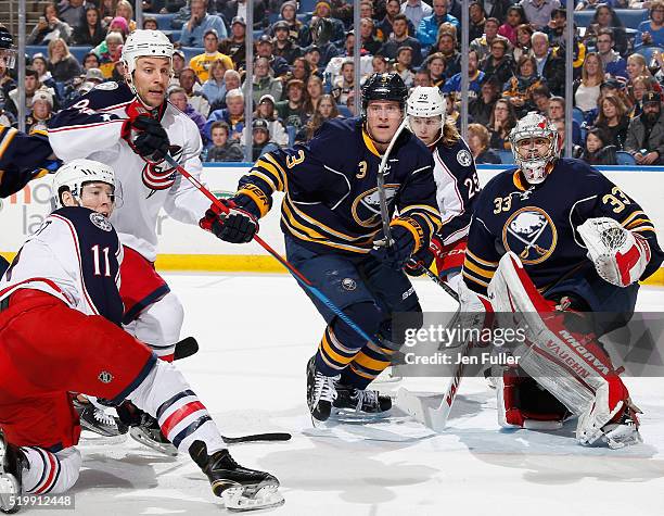 Jason Kasdorf of the Buffalo Sabres keeps an eye on the puck in the air as teammate Mark Pysyk defends against Matt Calvert, Gregory Campbell and...
