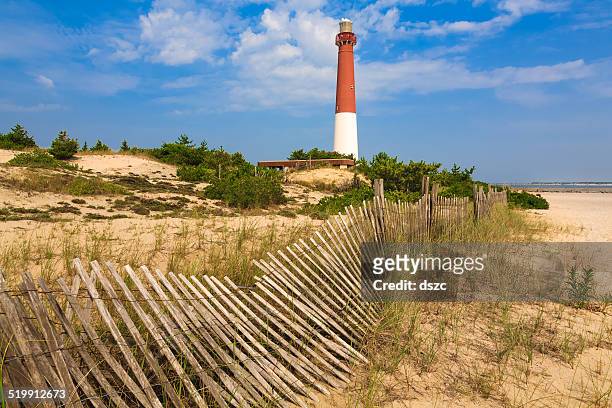 barnegat lighthouse, sand, beach, dune fence, new jersey - long beach island stockfoto's en -beelden