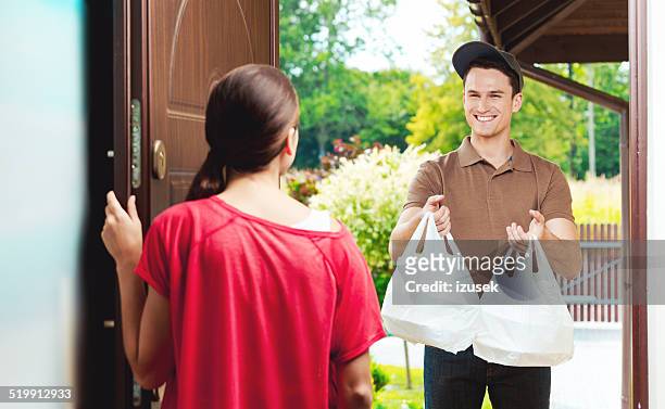 delivery man delivering chinese take away food - take away food courier stock pictures, royalty-free photos & images