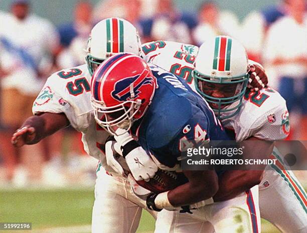Miami Dolphins safetys Louis Oliver and Michael Stewart bear down on the Buffalo Bills running back Darick Holmes during the second quarter in Miami...