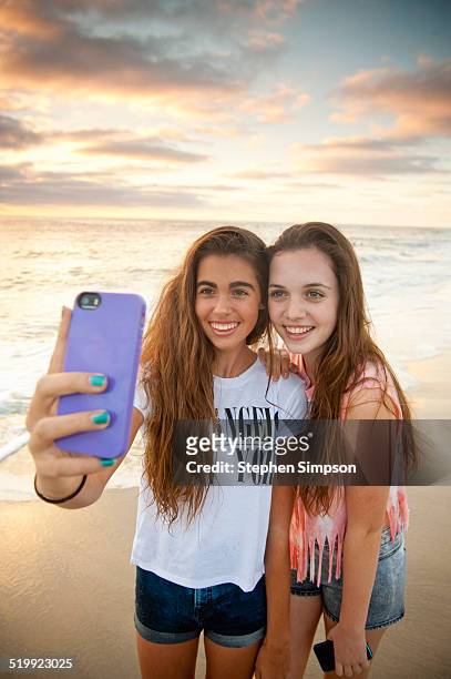 girlfriends at the beach taking "selfies" photos - 13 year old girls in shorts stock pictures, royalty-free photos & images