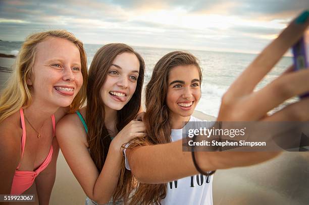 girlfriends at the beach taking "selfies" photos - blonde girl sticking out her tongue stock pictures, royalty-free photos & images