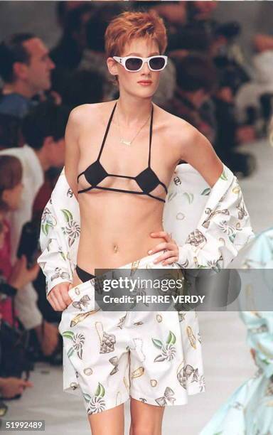 Karl Lagerfeld cuts a shirt and elastic-waisted "boxer"shorts beach ensemble from signature printed cotton to cover a micro-bikini for sleeveless...