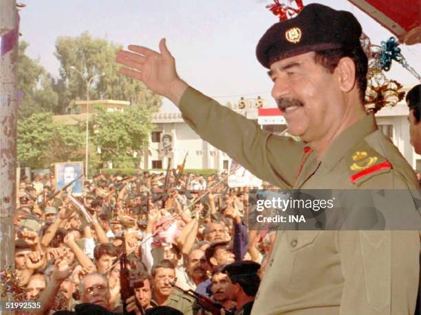 Iraqi President Saddam Hussein waves to his supporters in his first public appearance in Baghdad 18 October since he was reelected as President for...