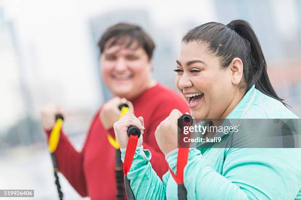 hispanic woman, friend exercising with resistance bands - overweight stock pictures, royalty-free photos & images