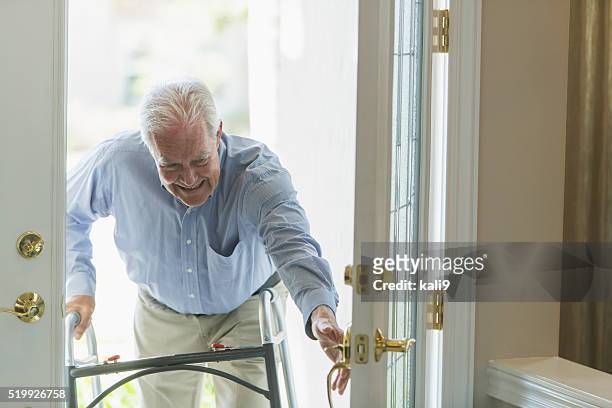 uomo anziano con deambulatore, tornando a casa con ingresso - solo un uomo anziano foto e immagini stock