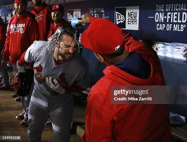 Infielder Carlos Martinez of the St. Louis Cardinals dumps water on pinch hitter Greg Garcia after Garcia's ninth inning home run during the game...