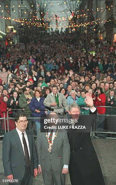 President Bill Clinton waves at the crowd 30 November after a walk in Londonderry with the Mayor John Kerr and local deputy John Hume. Clinton spoke...