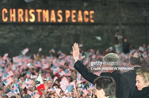 President Bill Clinton waves to the crowd after his speech in the Guildhall Square in Londonderry, United Kingdom 30 November as First Lady Hillary...