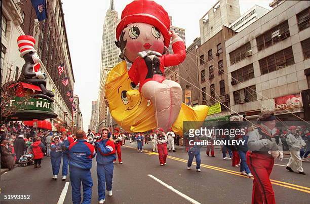 Handlers pull the Betty Boop balloon past Macy's department store , with the Empire State building in the background, 23 November during the 69th...