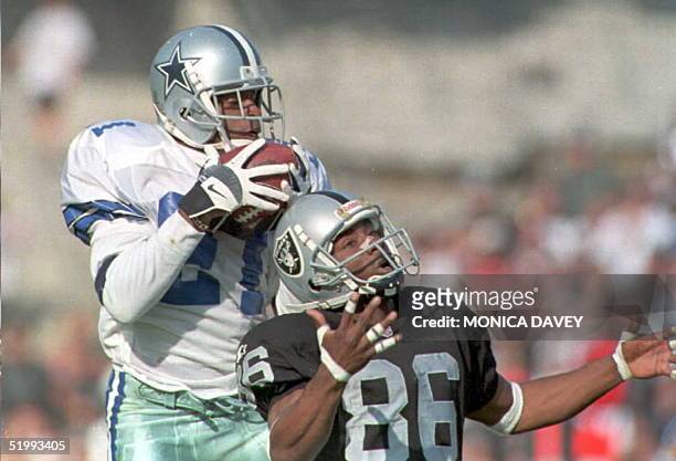 Dallas Cowboys Deion Sanders intercepts a ball intended for Oakland Raiders wide receiver Raghib Ismail during first quarter action 19 November in...