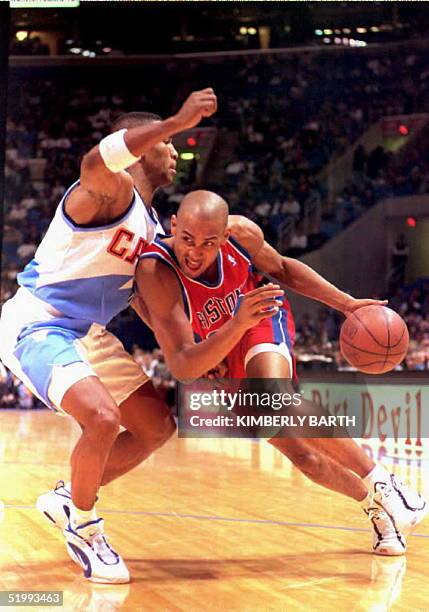 Detroit Pistons forward Grant Hill drives for the basket against Cleveland Cavaliers guard Bobby Phills in the first half of game action at Gund...