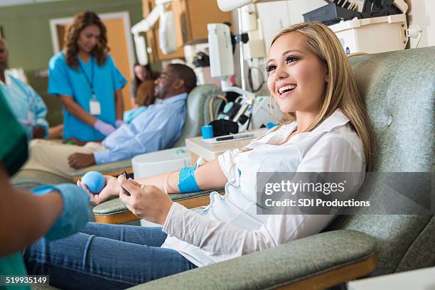 woman donating blood in busy hospital donation bank - blood donation 個照片及圖片檔