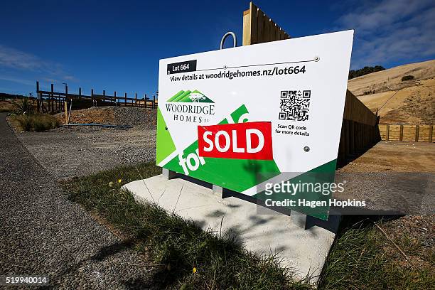 Sold' sign is seen on an empty lot in the suburb of Woodridge on April 9, 2016 in Wellington, New Zealand. Increased demand for property in...