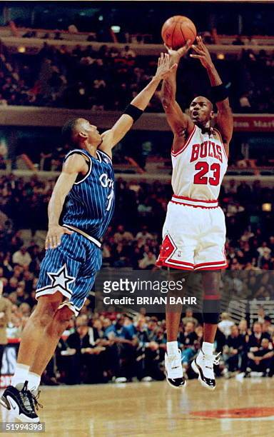 Chicago Bulls guard Michael Jordan shoots a jump shot over Orlando Magic guard Anfernee Hardaway 13 December during the first period at the United...