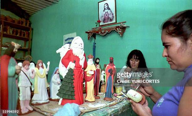 Mujeres artezanas pintan figuras que representan a los "Tres Reyes Magos" y Santa Claus entre otros personajes biblicos alusivos a la navidad en...