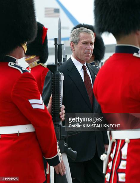 President George W. Bush views the Canadian Royal Guard upon his arrival at Calgary International Airport 25 January 2002 in Calgary, Alberta,...