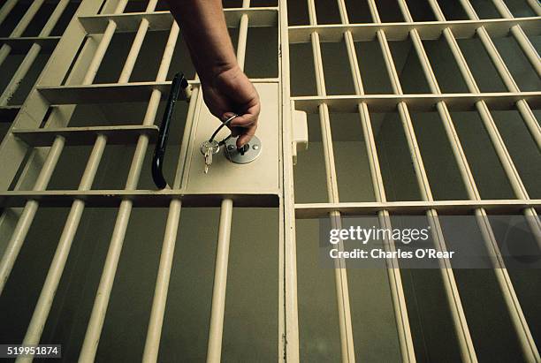 key in jail cell door - porte de prison photos et images de collection